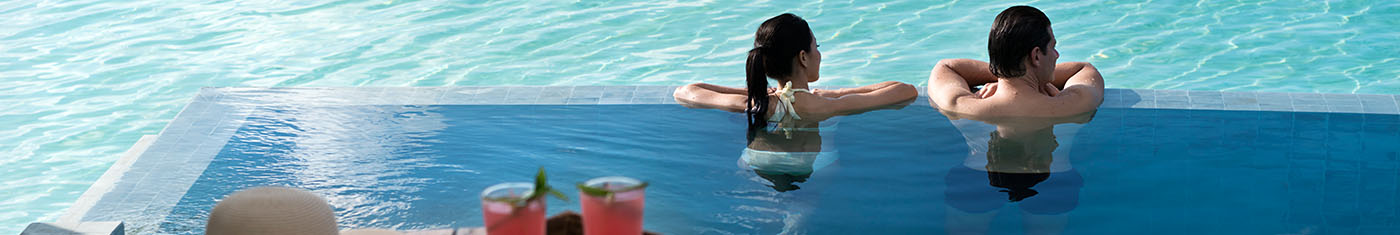 Couple enjoying gazing at the horizon while having a bath in infinity pool