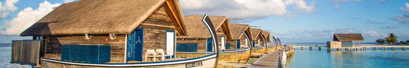 Boat shaped overwater villas in Maldives with wooden pathway to them