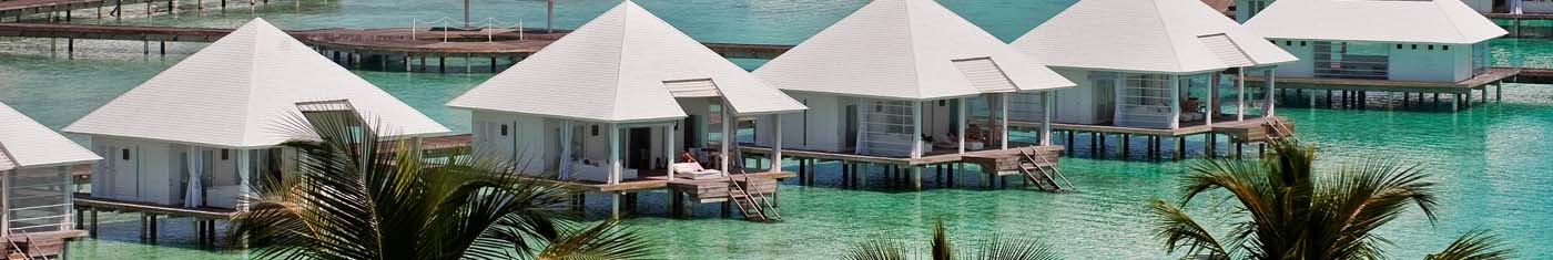 Distance view of overwater villas with pyramid shaped roofing
